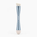 The PrimePrometics™ 4-in-1 Hairline Powder Brush features a sleek silver handle with a double-ended design: one side has an angled Hairline Powder brush head made of cruelty-free bristles, while the opposite end includes a soft, rounded beige sponge applicator.