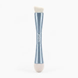 The PrimePrometics™ 4-in-1 Hairline Powder Brush features a sleek silver handle with a double-ended design: one side has an angled Hairline Powder brush head made of cruelty-free bristles, while the opposite end includes a soft, rounded beige sponge applicator.