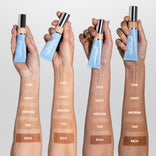 Three arms of different skin tones display swatches labeled fair, light, medium, tan, and rich. Each hand holds a tube of Primaskin foundation against a plain background.