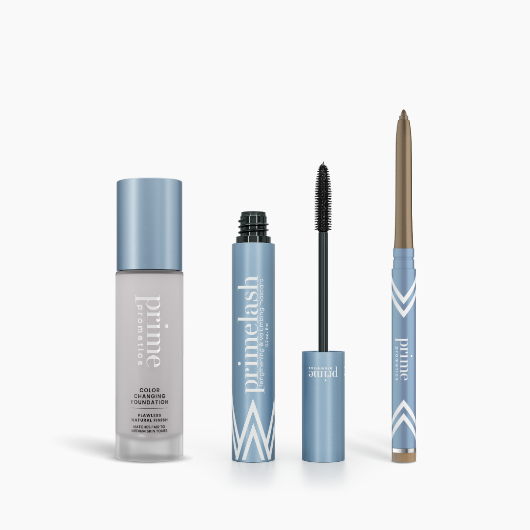 The PrimePrometics™ Prime Heroes Set features three silver and blue products: a Color Changing Foundation bottle, an exposed-wand PrimeLash Mascara tube, and a twist-up eyeliner pencil, all branded “Prime Lash.”.