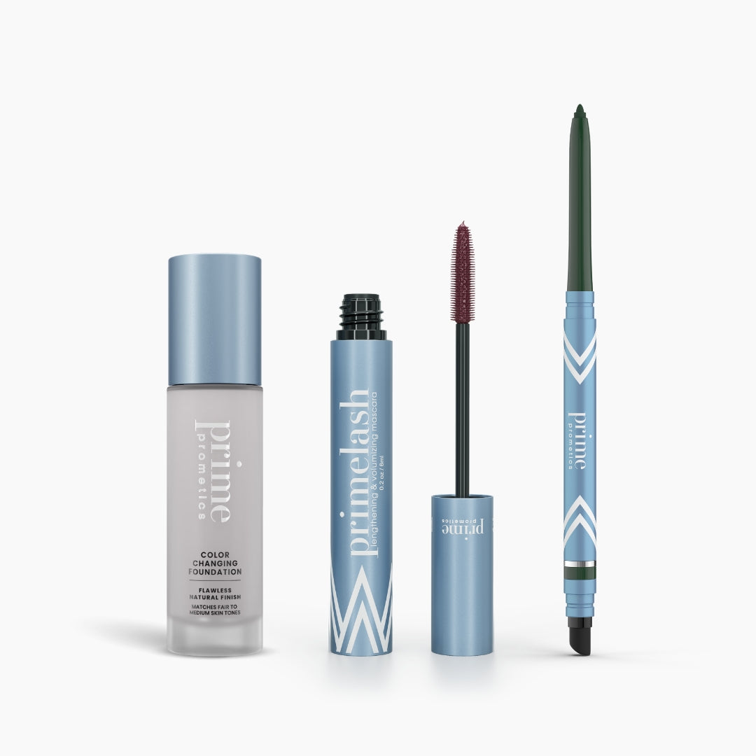 The PrimePrometics™ Prime Heroes Set features a blue bottle of Color Changing Foundation with a silver cap, an open PrimeLash Mascara with a maroon brush, and a PrimeEyes Glide eyeliner pencil, all displayed on a white background.