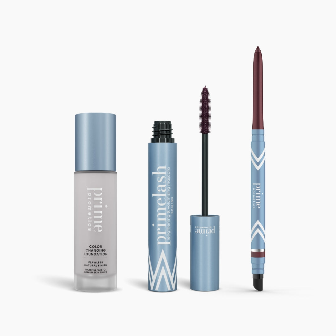 Three blue and silver PrimePrometics™ products from the Prime Heroes Set stand side by side: a Color Changing Foundation, an open PrimeLash Mascara with wand, and a twist-up PrimeEyes Glide eyeliner, all labeled "primelash.