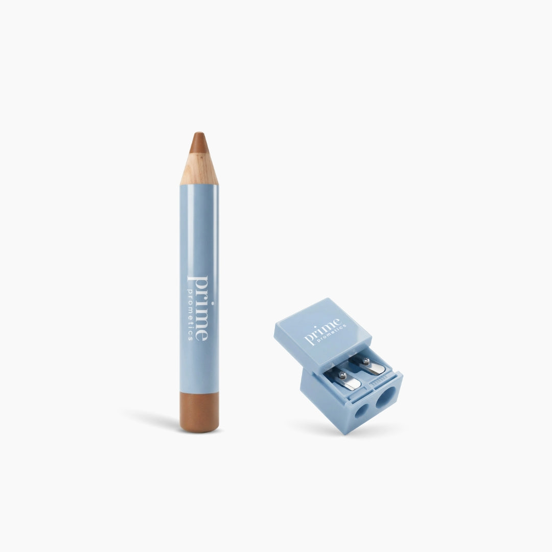 A thick, light blue PrimePrometics™ Concealer + Sharpener set is shown on a white background, featuring a wooden-tip pencil and matching blue dual-blade sharpener, both labeled with the brand name.