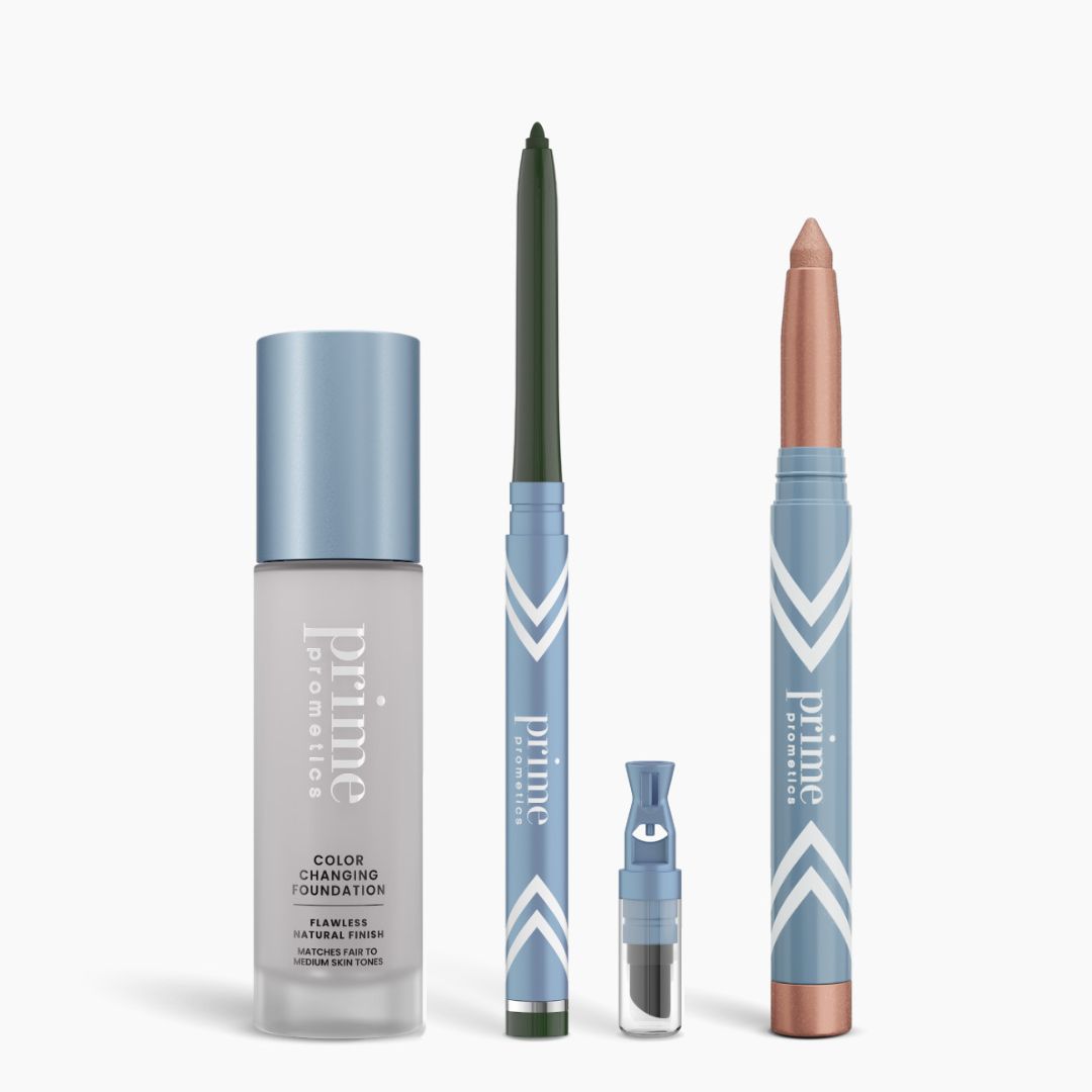 Four PrimePrometics™ All-Day Confidence Bundle products in light blue and silver packaging are displayed: a color changing foundation, green glide eyeliner, dark powder container, and shimmery peach brightener eyeshadow stick.
