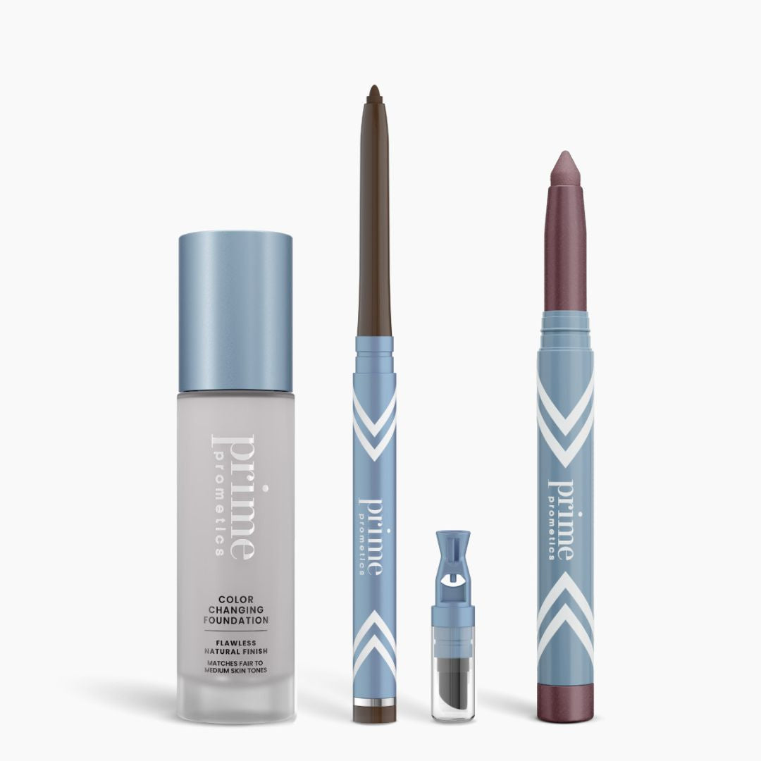 The PrimePrometics™ All-Day Confidence Bundle includes a color-changing foundation, brown glide eyeliner pencil, blue-capped tiny vial, and mauve eyeshadow stick—all in sleek light blue and white packaging.