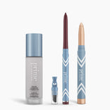 Four PrimePrometics™ All-Day Confidence Bundle products in blue packaging stand upright: a color changing foundation, a dropper vial, a burgundy pencil, and a gold cream stick. The background is white.
