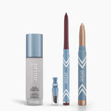 Four makeup products from PrimePrometics™' All-Day Confidence Bundle stand upright on a white background: a color changing foundation, brightener vial, burgundy eyeliner pencil, and champagne eyeshadow stick—all in blue and white packaging.