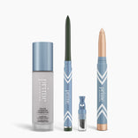 Four blue and silver PrimePrometics™ products from the All-Day Confidence Bundle—including a color changing foundation, glide eyeliner pencil, brightener vial, and crayon highlighter—stand upright on a white background.