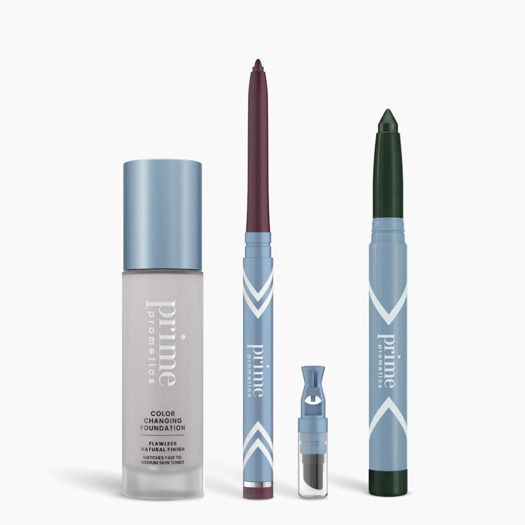 The PrimePrometics™ All-Day Confidence Bundle—featuring a color changing foundation, burgundy eyeliner, eyeshadow pod, and green brightener—rests in sleek blue and silver packaging against a white background.