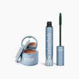 The PrimePrometics™ Beauty Essentials set features a blue compact with hairline powder and applicator next to an open tube of PrimeLash mascara, displaying the mascara wand and branding on a white background.