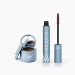 The Beauty Essentials set by PrimePrometics™ features an open blue hairline powder makeup with sponge and a blue tube of PrimeLash mascara, wand exposed, all displayed on a white background.