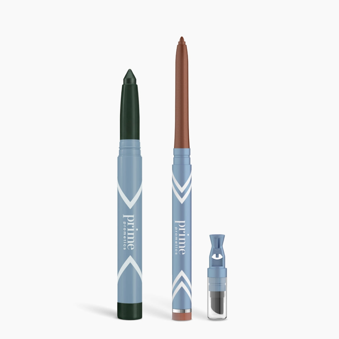 The Eye Lift Duo by PrimePrometics™—a dark green crayon, a brown crayon, and a small blue “prime promise” container—stands upright against a white background, showcasing an eyeliner for women over 50 and an illuminating eye tint.