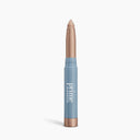 The Mini PrimeEyes Brightener by PrimePrometics™ is a shimmery beige eyeshadow stick with a twist-up design and a blue barrel, displayed against a white background.