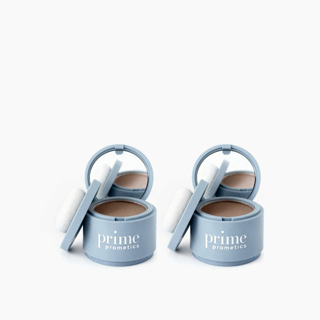 Two round light blue PrimePrometics™ containers labeled "2pcs Instant Coverage Hairline Powder" feature open lids, mirrors, and white applicator puffs. They provide instant hairline coverage or act as a hair concealer. Displayed on a plain white background.