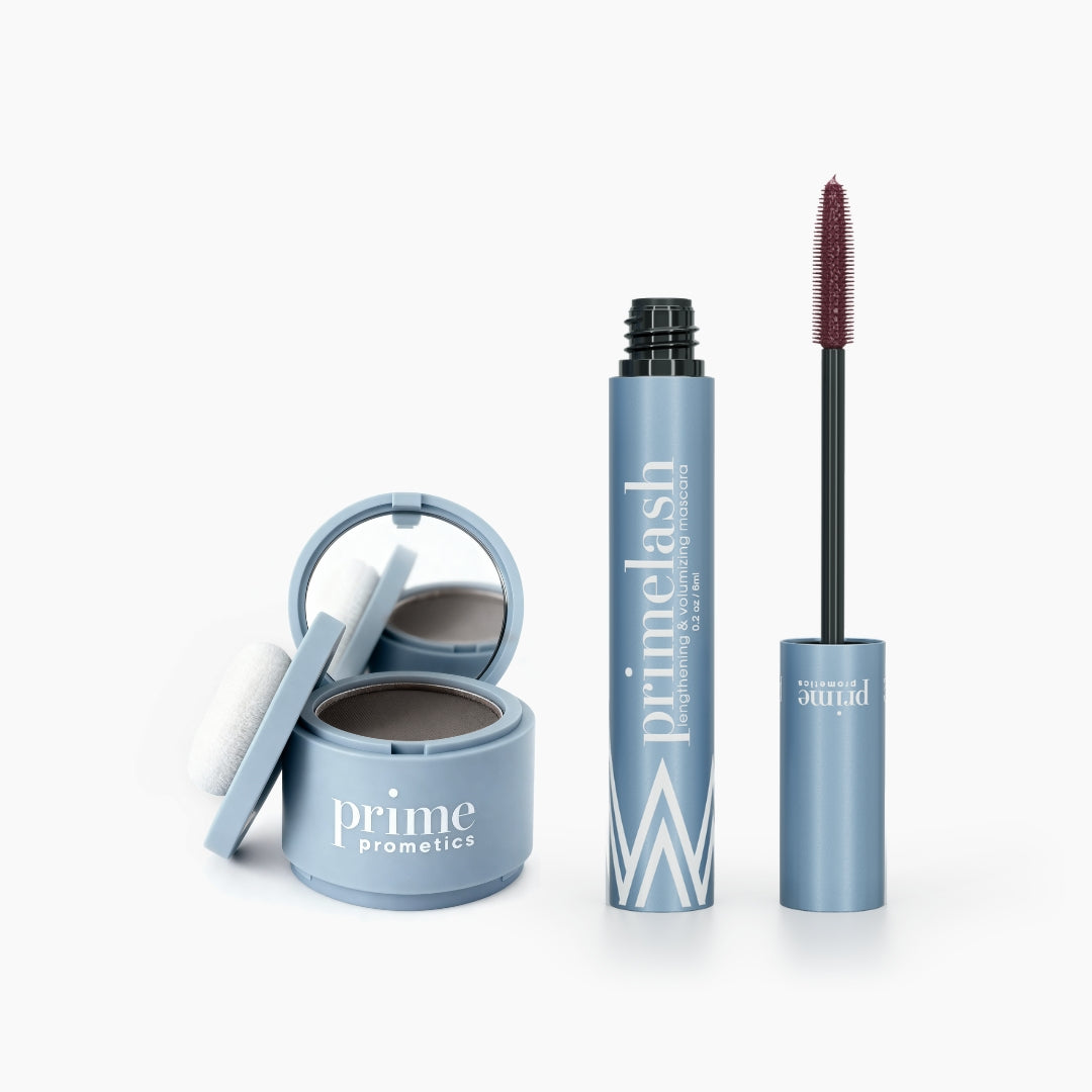The PrimePrometics™ Beauty Essentials Set includes an open compact with mirror and puff, and an open tube with brush, both in blue, displayed on a white background.