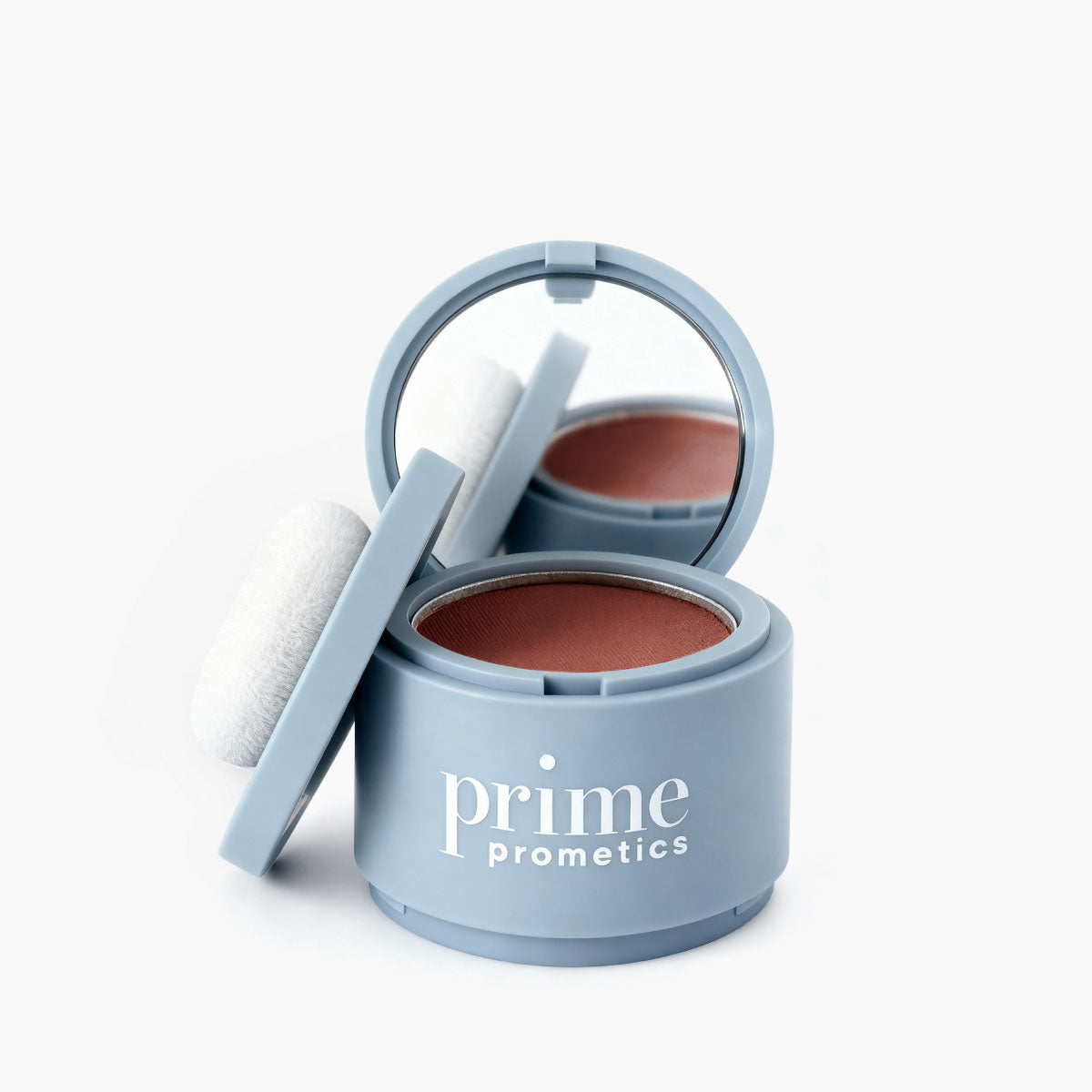 A blue round container of PrimePrometics™ Instant Coverage Hairline Powder features a built-in mirror, attached puff, and rose-toned powder for flawless gray root touch-up and hair thinning coverage.