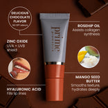 A tube of Prime Prometics lip product is surrounded by chocolate pieces and ingredient images, with text highlighting benefits: chocolate flavor, zinc oxide for sun protection, hyaluronic acid, rosehip oil, and mango seed butter.
