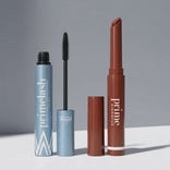 The Instant Red Carpet Look Set by PrimePrometics™ features an open blue mascara tube with wand and a brown lipstick tube sans cap, both displayed on a light surface before a gray backdrop.
