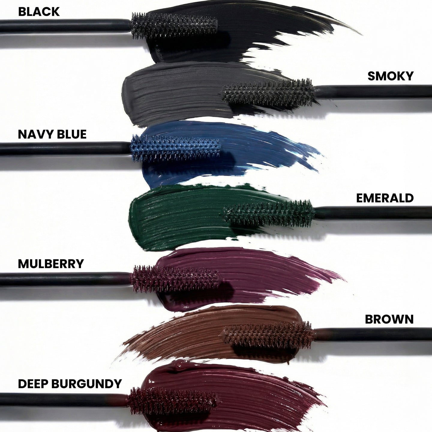 Six K.I.S.S Bundle mascara wands from PrimePrometics™ display swatches of different shades—black, smoky, navy blue, emerald, mulberry, brown, and deep burgundy—each labeled beside its corresponding streak on a white background.
