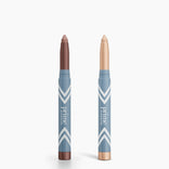 Two PrimePrometics™ PrimeEyes Eye Brightener sticks are shown with caps off—one shimmery brown, one shimmery light beige—both in blue chevron packaging. Perfect duo for effortless eye brightening and care.
