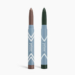 Two blue chevron-patterned sticks—one with a metallic brown tip, the other deep green—stand upright on white. Labeled 2pcs PrimeEyes Eye Brightener by PrimePrometics™, they're perfect for eye care and adding radiance.