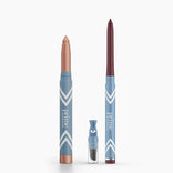Two blue PrimePrometics™ Eye Lift Duo pencils with white chevrons stand upright: a thick, shimmery beige crayon and a slim, dark red eyeliner for women over 50. A small sharpener is placed in front of them. Both pencils are water-resistant.