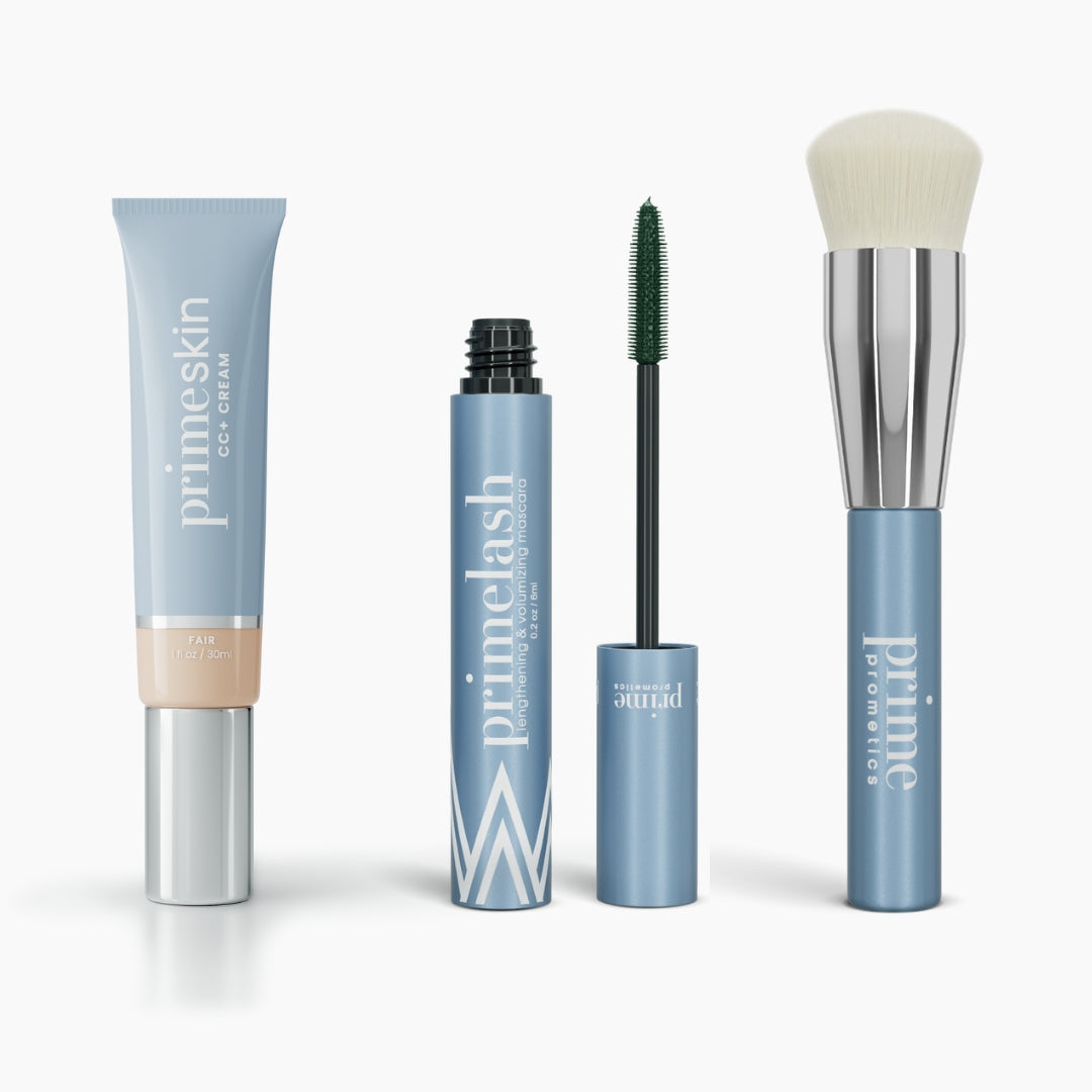 The PrimePrometics™ Effortless Beauty Complete Bundle features four makeup essentials in sleek blue packaging: Primeskin CC+ Cream, open and closed Primeskin mascaras, and a foundation brush with a silver handle and white bristles.