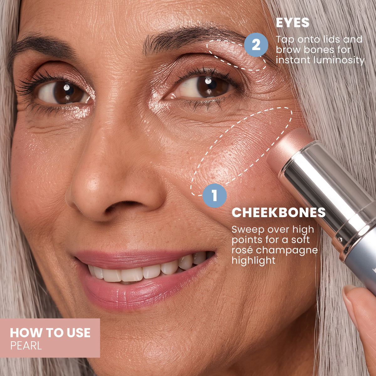Eine Frau mit langen grauen Haaren und einem strahlenden Lächeln führt den PrimePrometics™ PrimeWand Trinity Creme-Stift sanft über ihren Wangenknochen und zeigt damit, wie mühelos diese Formel das Make-up für reife Haut aufwertet. Tipps auf dem Bildschirm verdeutlichen, wie das Produkt auf Augen und Wangen angewendet wird, um einen strahlenden, zarten Rosé-Champagner-Schimmer zu erzielen.