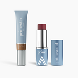 Three blue PrimePrometics™ Complete Face Bundle products—a PrimeSkin CC+ Cream tube with a brown shade, a prime-labeled twist-up stick (likely PrimeWand Pigment), and its cap—are shown on a white background.