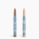 Two blue PrimePrometics™ Complete Eye Sticks Kit tubes, one brown and one light beige, both double as matte eyeshadow and eye brightener. They feature pointed tips and are shown against a white background.