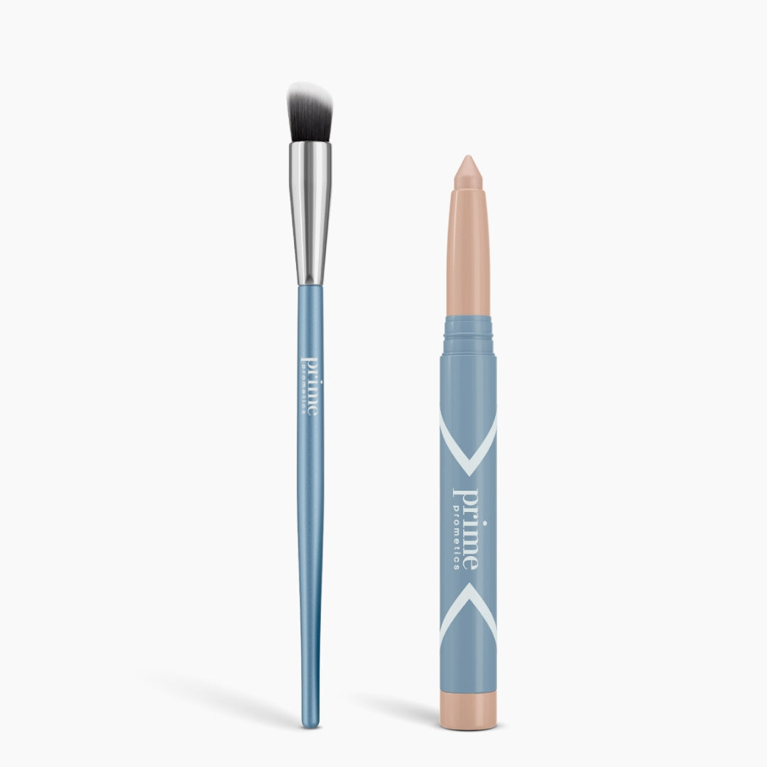 A blue-handled brush with a silver ferrule stands beside a blue crayon-style matte stick with a beige tip, both labeled "PrimePrometics™," from the Seamless Shadow Bundle Matte, on a white background.