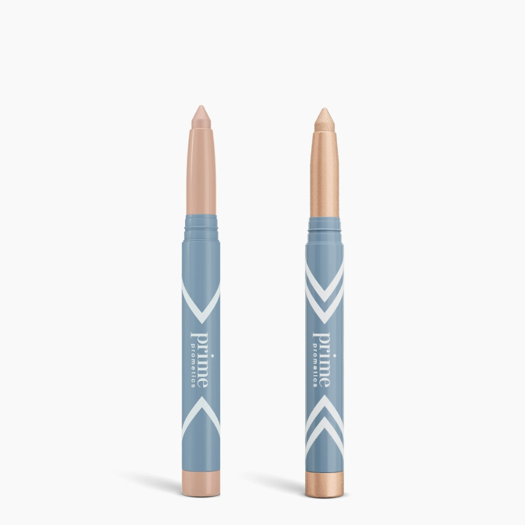 Two blue Complete Eye Sticks Kit by PrimePrometics™ stand upright on a white background. One has its beige cap on; the other reveals a light nude shade, ideal as an Eye Brightener or Matte Eyeshadow. Both feature prime PROMISE labels.