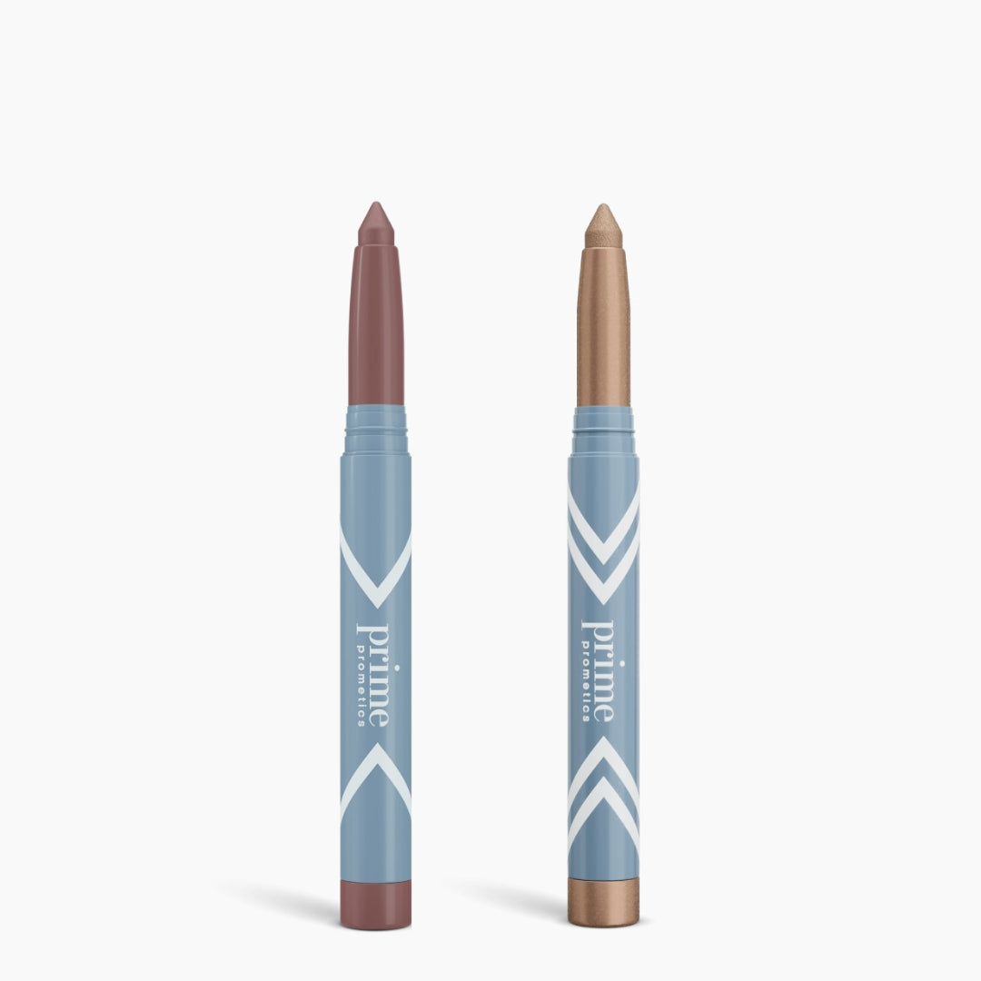 The Complete Eye Sticks Kit by PrimePrometics™ features two light blue tubes—one mauve, one shimmery gold—standing upright against a white background, ideal as an eye brightener or matte eyeshadow.