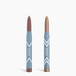 The Complete Eye Sticks Kit by PrimePrometics™ features two light blue tubes—one mauve, one shimmery gold—standing upright against a white background, ideal as an eye brightener or matte eyeshadow.